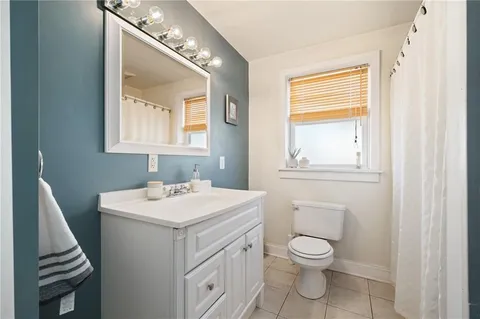 a bathroom with a toilet a sink and a mirror