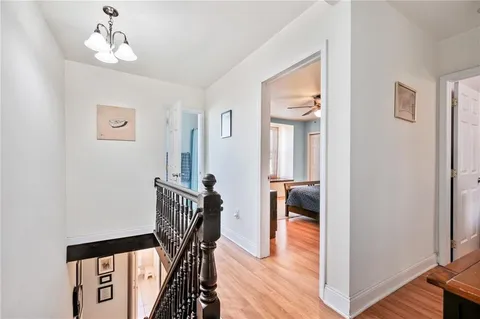 a view of a hallway with wooden floor and staircase