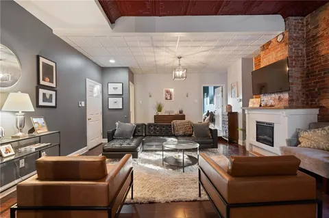 a living room with furniture a flat screen tv and a fireplace