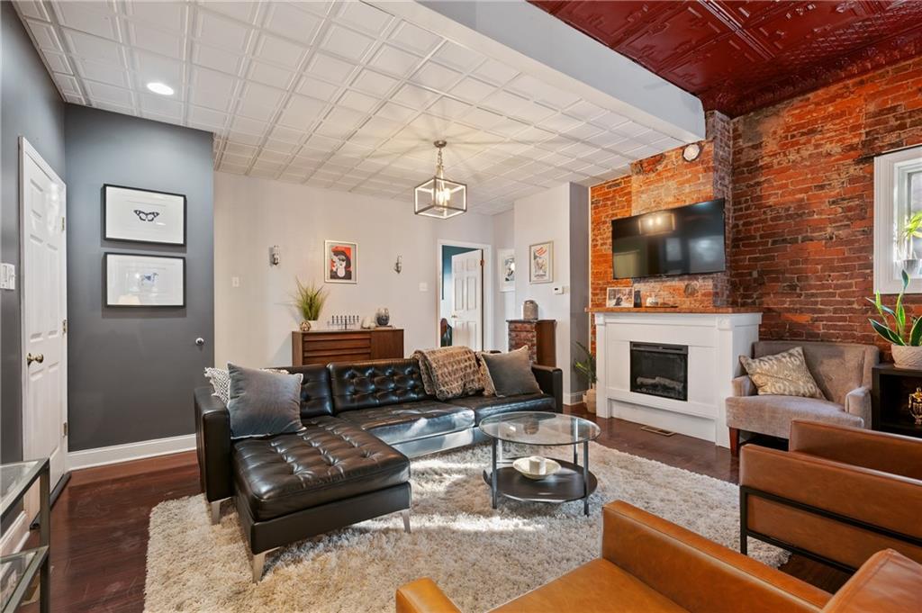 3037 Brereton Street Pittsburgh, PA 15219 - Photo 8 of 36 a living room with furniture a flat screen tv and a fireplace