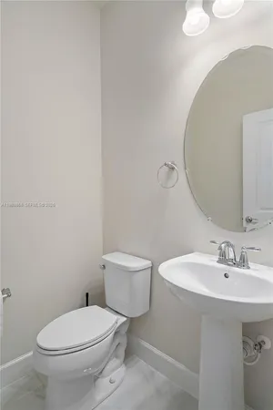 a white toilet sitting next to a bathroom sink