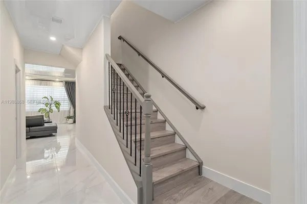 a view of entryway and hall with wooden floor
