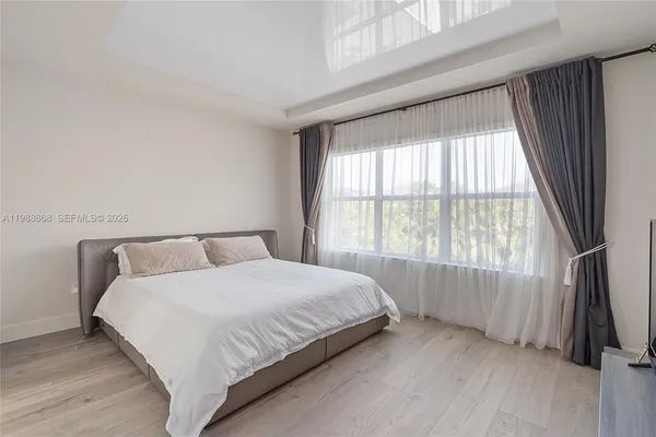 a large bed sitting in a bedroom next to a window