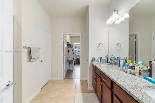 a bathroom with a granite countertop sink a large mirror and shower