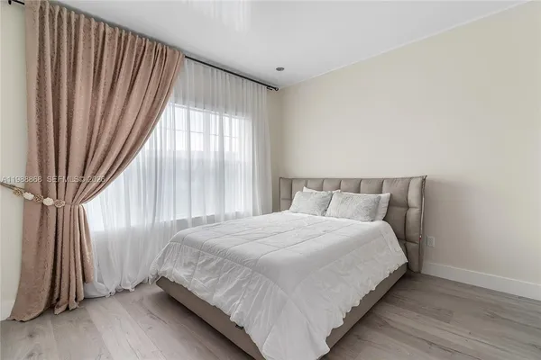 a large bed sitting in a bedroom next to a window