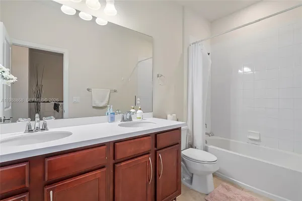 a bathroom with a toilet a sink a tub and mirror