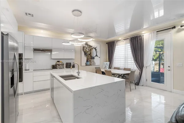 a kitchen that has a sink a stove and chairs