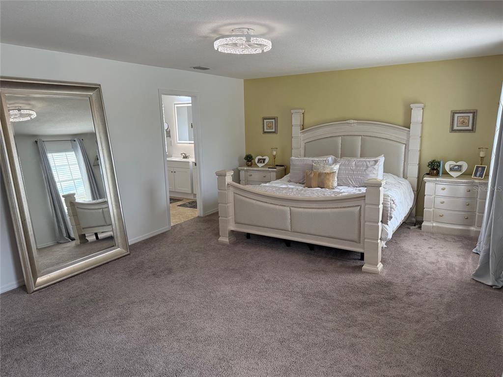12236 Fairlawn Drive Riverview, FL 33579 - Photo 25 of 52 a spacious bedroom with a bed and a mirror