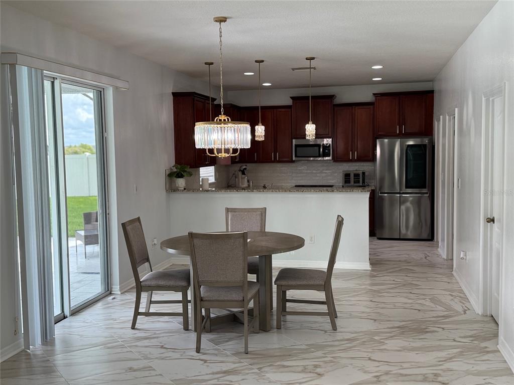 12236 Fairlawn Drive Riverview, FL 33579 - Photo 9 of 52 a view of a dining room with furniture a chandelier and wooden floor