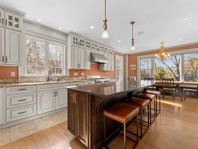a kitchen with a stove a refrigerator and a living room view