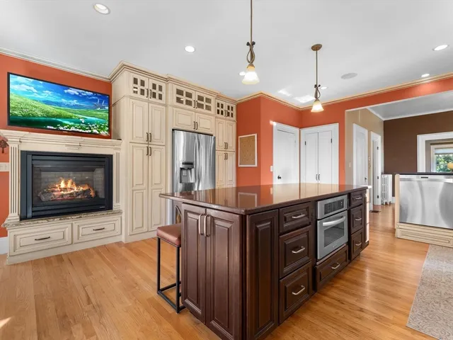 a kitchen with stainless steel appliances granite countertop a stove a refrigerator a oven and a wooden floors