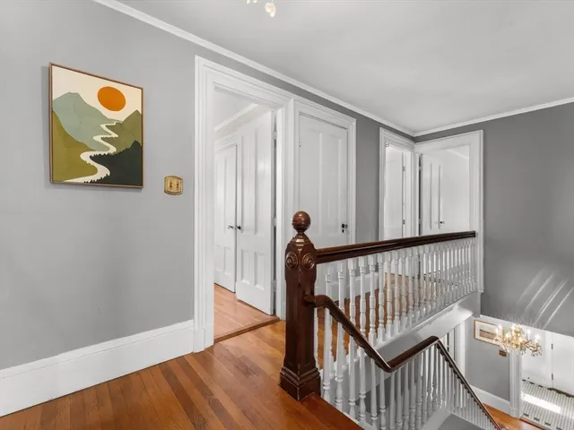 a view of a hallway with wooden floor and staircase
