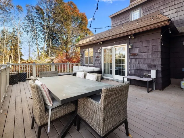 a view of a patio with table and chairs with wooden floor and fence