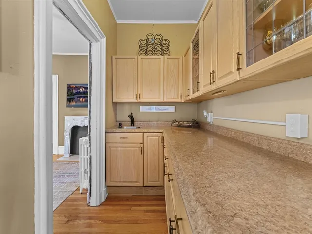 a view of kitchen with wooden floor and cabinets