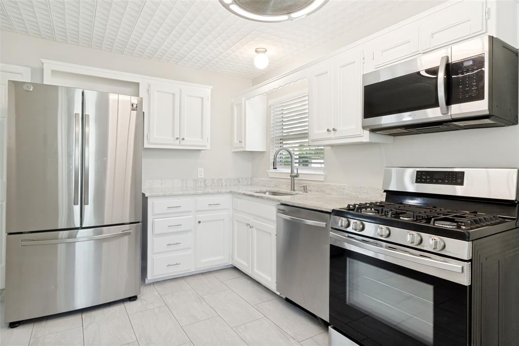 11524 Strand Street Dallas, TX 75218 - Photo 10 of 19 a kitchen with cabinets stainless steel appliances and wooden floor