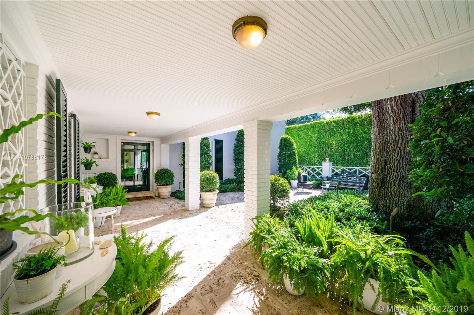 4955 Lakeview Drive Miami Beach, FL 33140 - Photo 14 of 55 a view of a patio with table and chairs potted plants with large tree