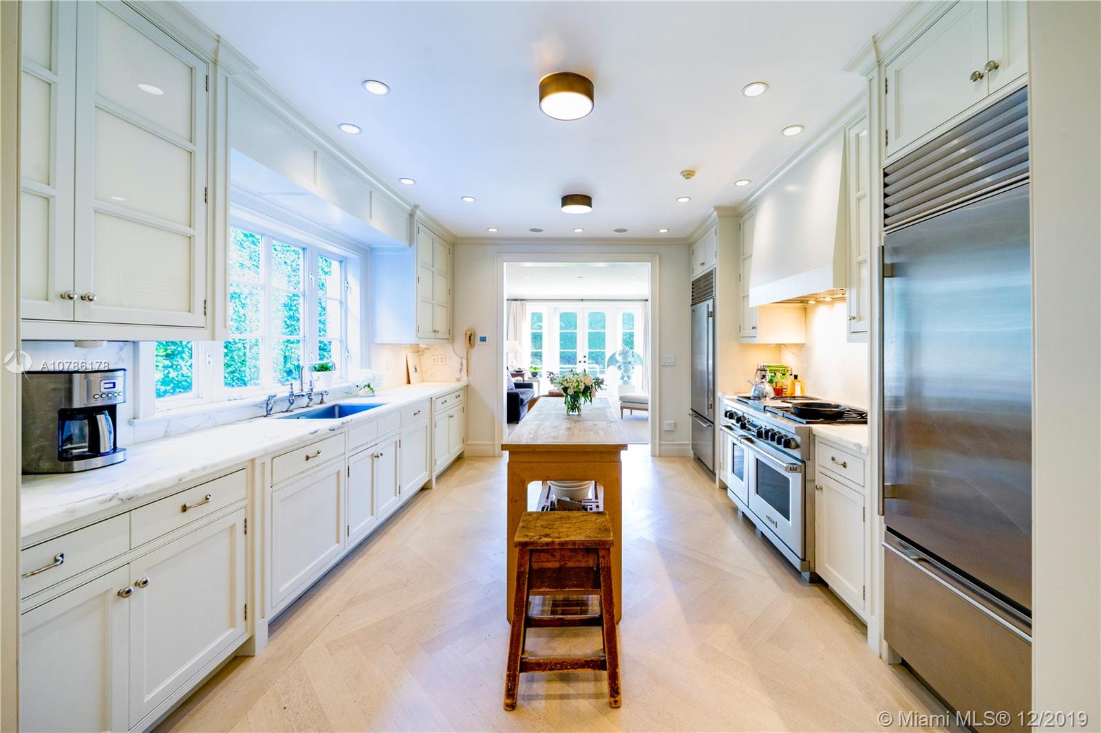 4955 Lakeview Drive Miami Beach, FL 33140 - Photo 23 of 55 a large white kitchen with granite countertop a large counter top stainless steel appliances and cabinets