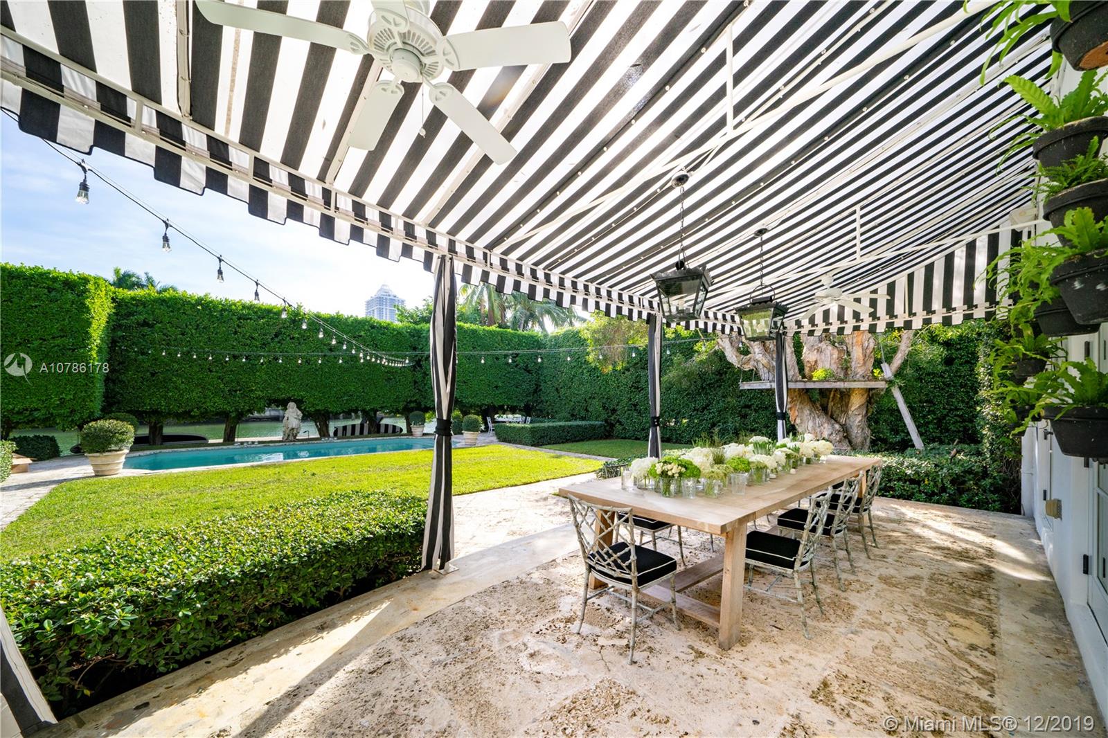 4955 Lakeview Drive Miami Beach, FL 33140 - Photo 28 of 55 a view of a swimming pool with a table and chairs