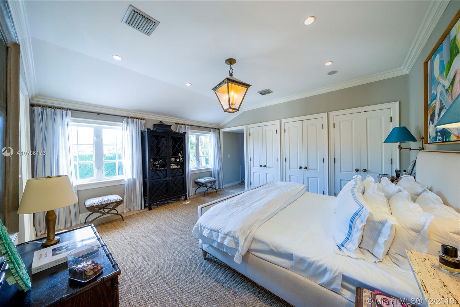 4955 Lakeview Drive Miami Beach, FL 33140 - Photo 42 of 55 a spacious bedroom with a bed mirror and a window