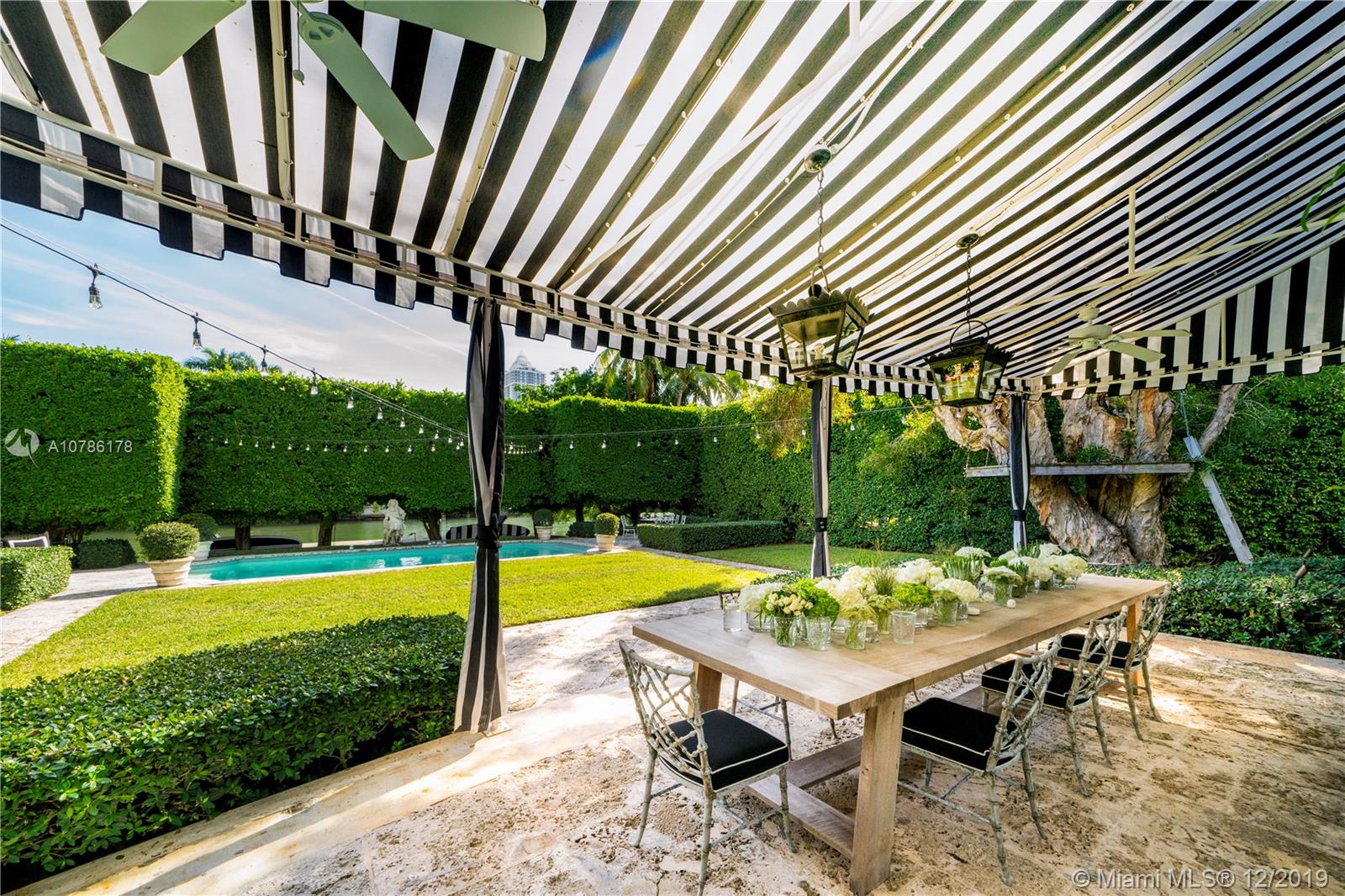 4955 Lakeview Drive Miami Beach, FL 33140 - Photo 6 of 55 a view of a patio with table and chairs with wooden floor and fence