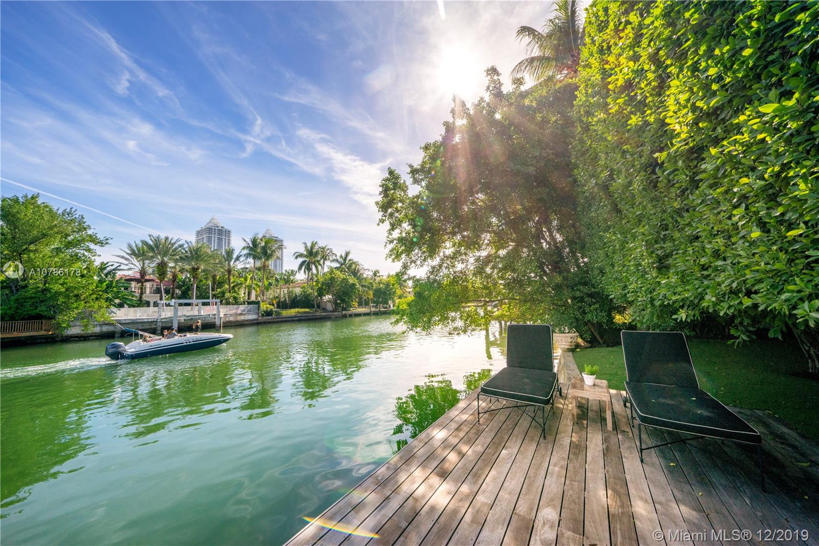 4955 Lakeview Drive Miami Beach, FL 33140 - Photo 7 of 55 a view of a lake with a garden and trees