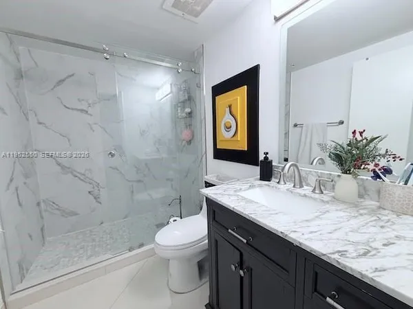 a bathroom with a granite countertop sink a toilet and shower
