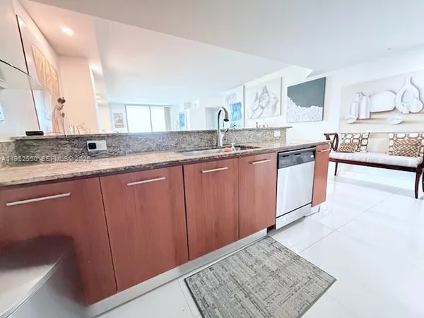 a large kitchen with granite countertop a sink and cabinets