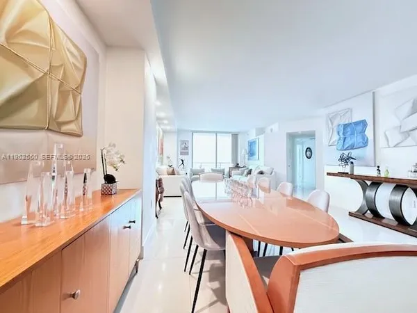 a dining room with furniture and a large window