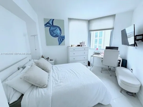 a bedroom with a bed a couch and dresser