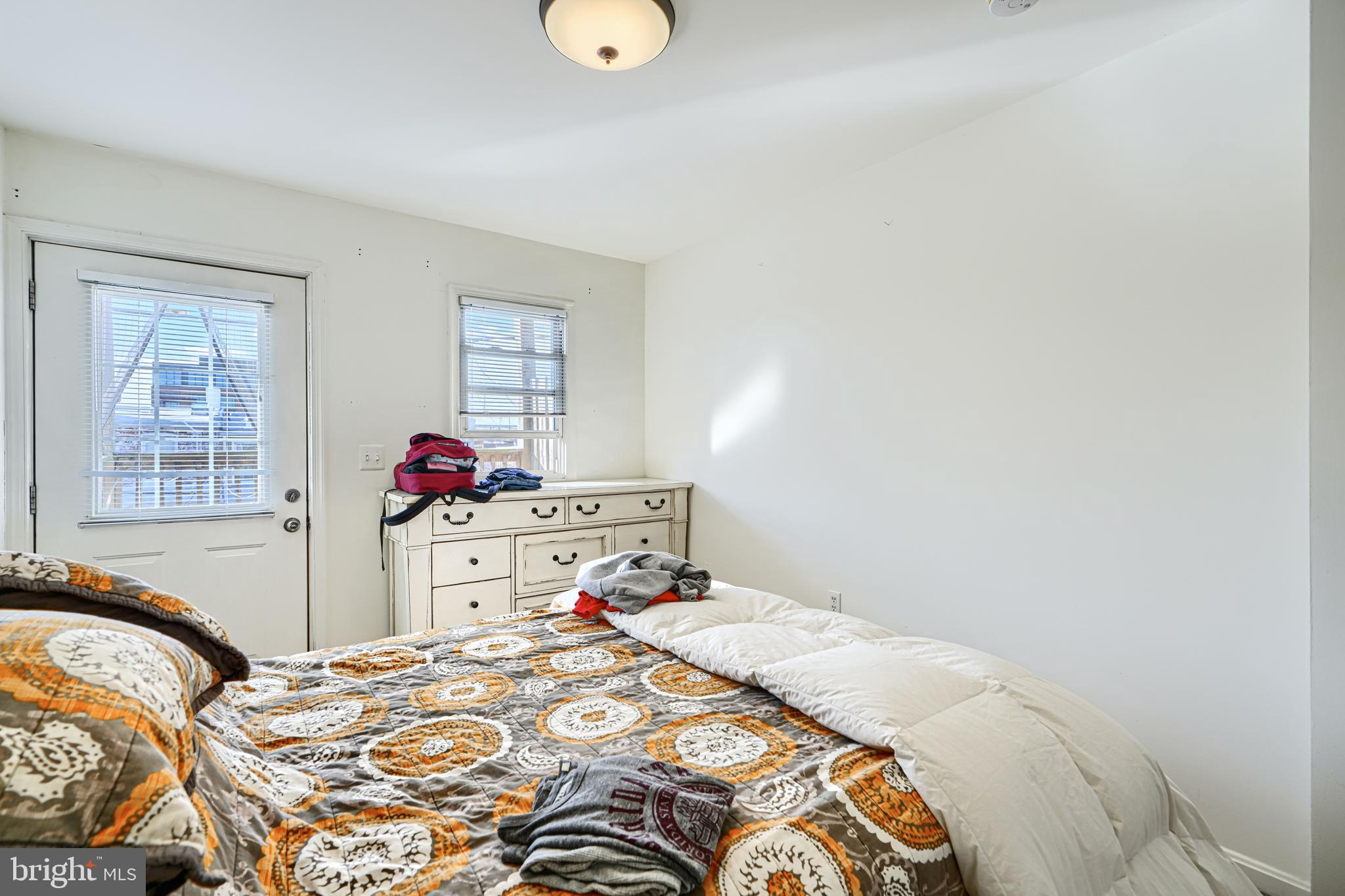 1312 South Hanover Street Baltimore, MD 21230 - Photo 23 of 53 a bed sitting in a bedroom next to a window with two mirror