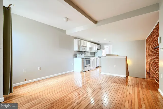 a view of a room with wooden floor and brick walls