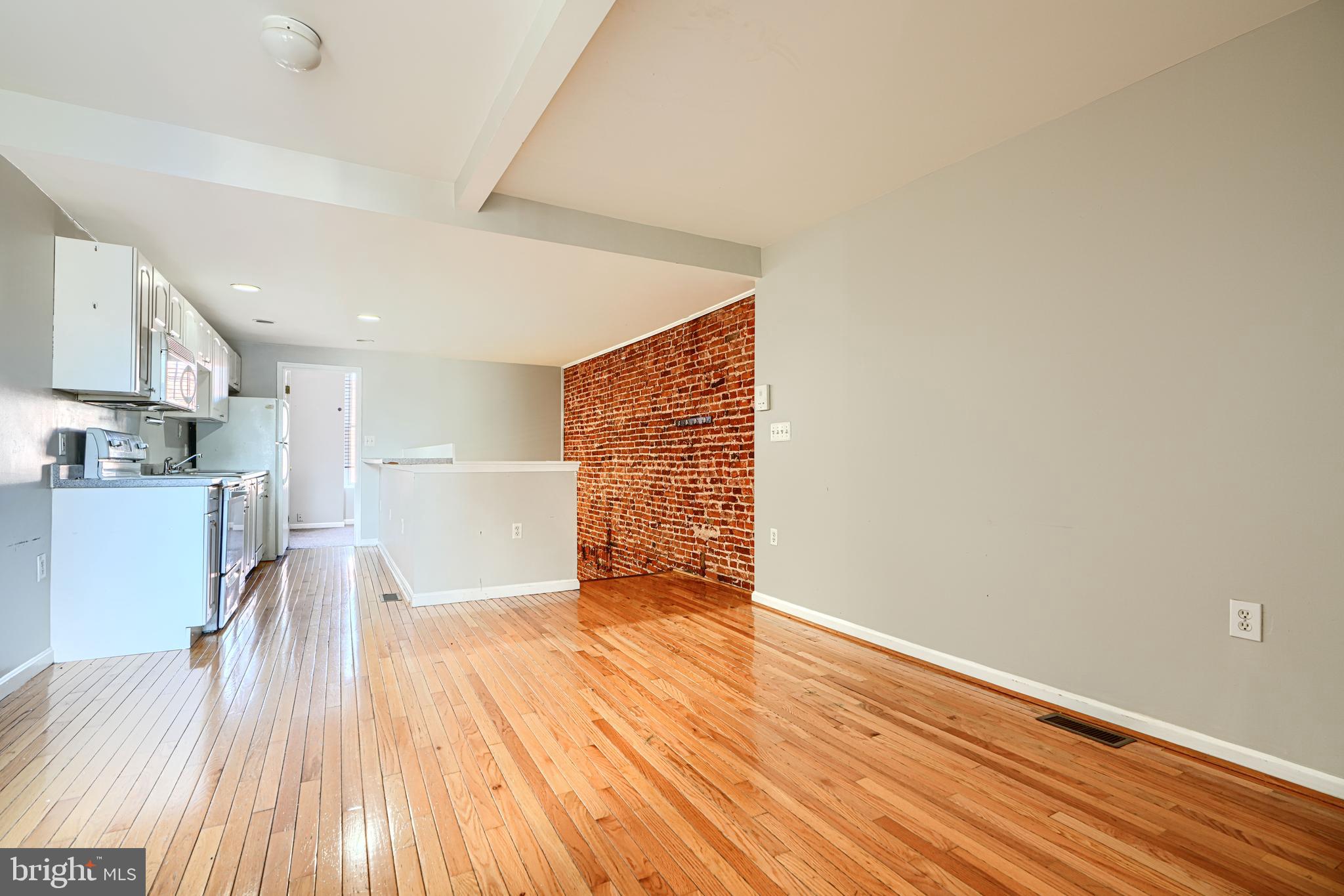1312 South Hanover Street Baltimore, MD 21230 - Photo 35 of 53 a view of empty room with wooden floor and kitchen
