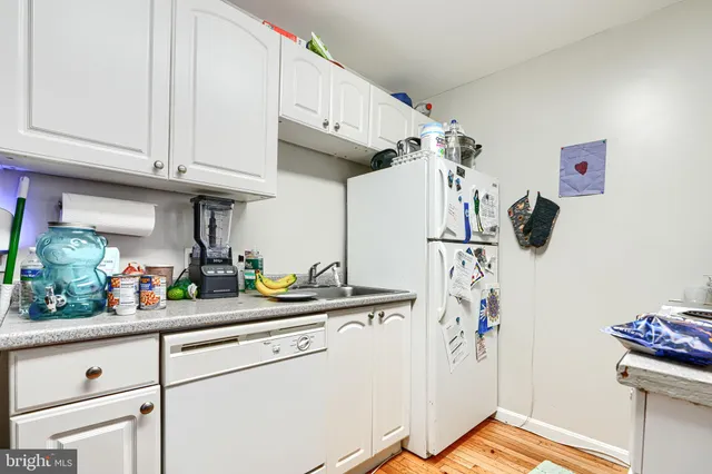 a kitchen with stainless steel appliances a sink a stove a chimney a refrigerator and cabinets