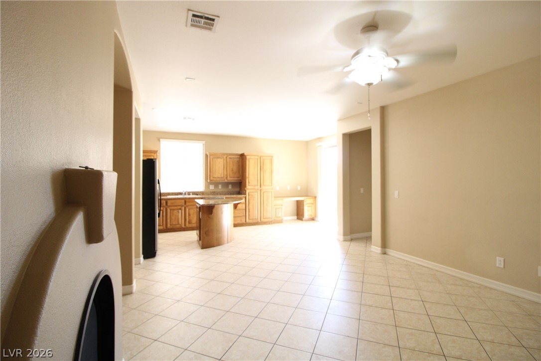 754 Rise Canyon Drive Henderson, NV 89052 - Photo 16 of 34 A combined living and kitchen area featuring light-toned tile flooring and a functional ceiling fan.