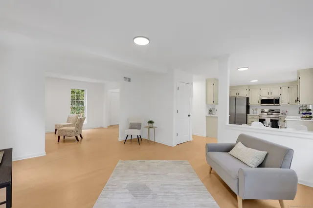 a living room with furniture a dining table and chairs with wooden floor