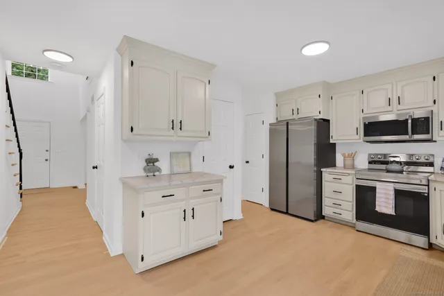 a kitchen with white cabinets and stainless steel appliances