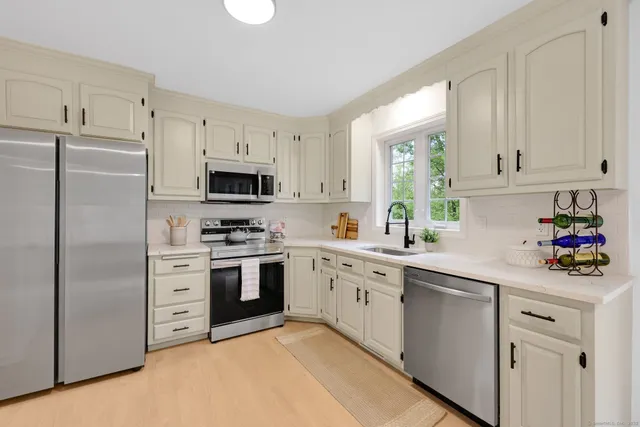 a kitchen with white cabinets and stainless steel appliances