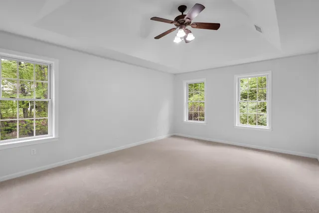 an empty room with windows and fan