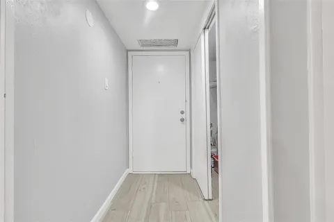 a view of a room with wooden floor and a door