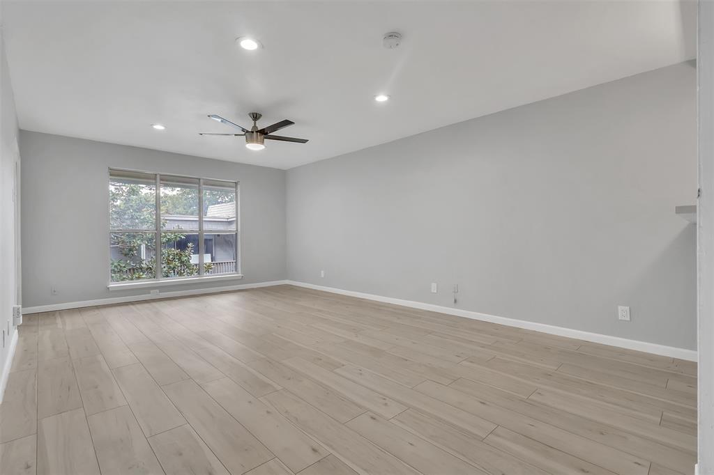 4837 Cedar Springs Road, Unit 321 Dallas, TX 75219 - Photo 2 of 14 an empty room with wooden floor and windows