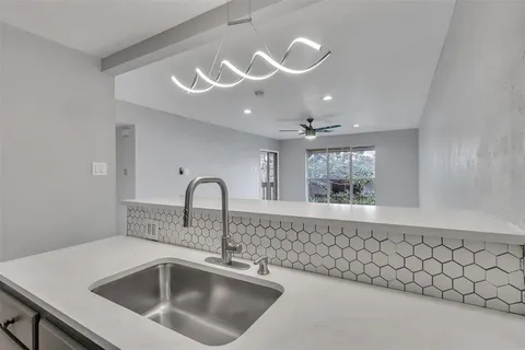 a close view of a sink a faucet and chandelier