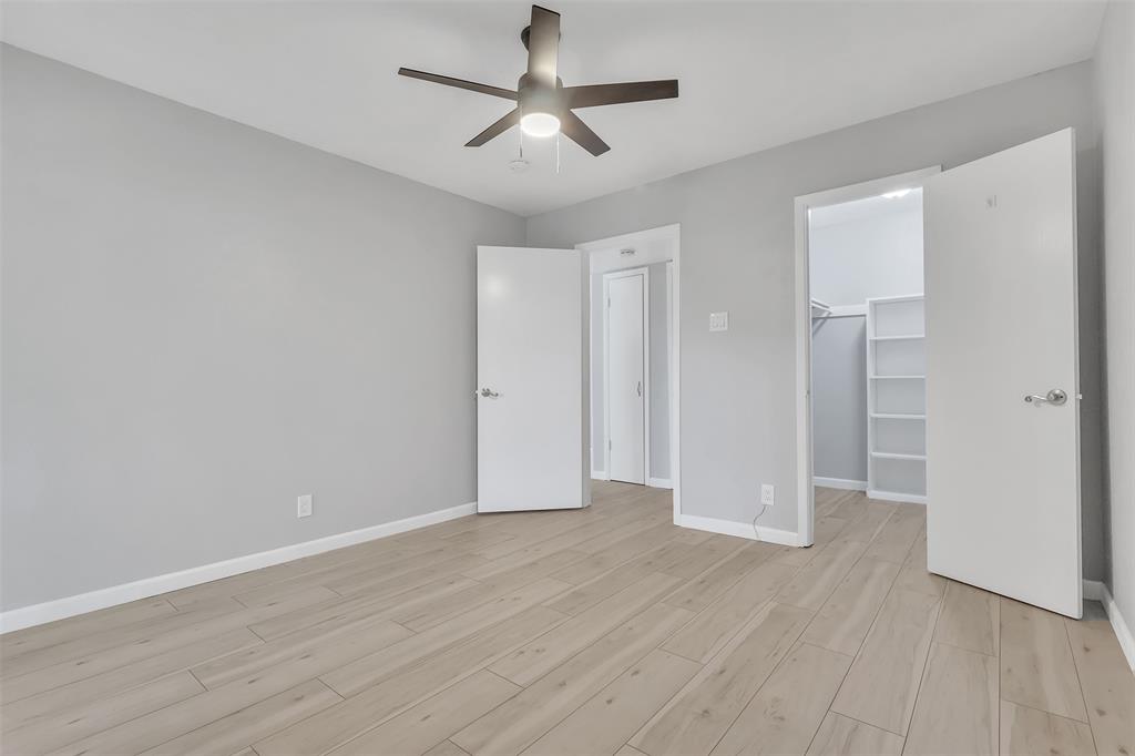 4837 Cedar Springs Road, Unit 321 Dallas, TX 75219 - Photo 9 of 14 an empty room with wooden floor and ceiling fan