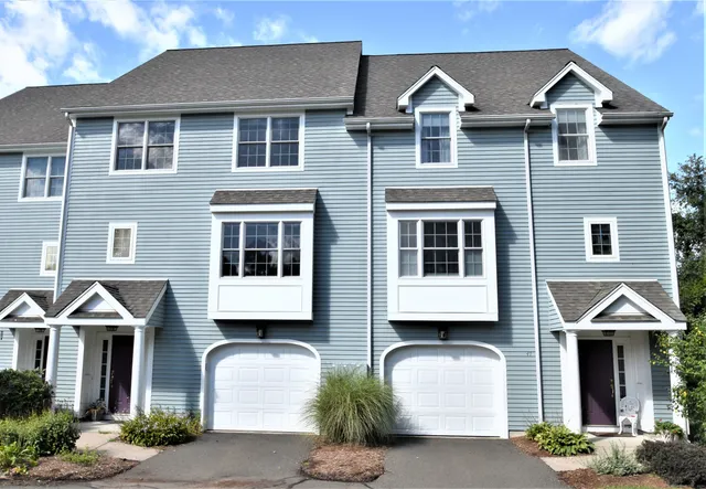 a front view of a house with a yard and balcony