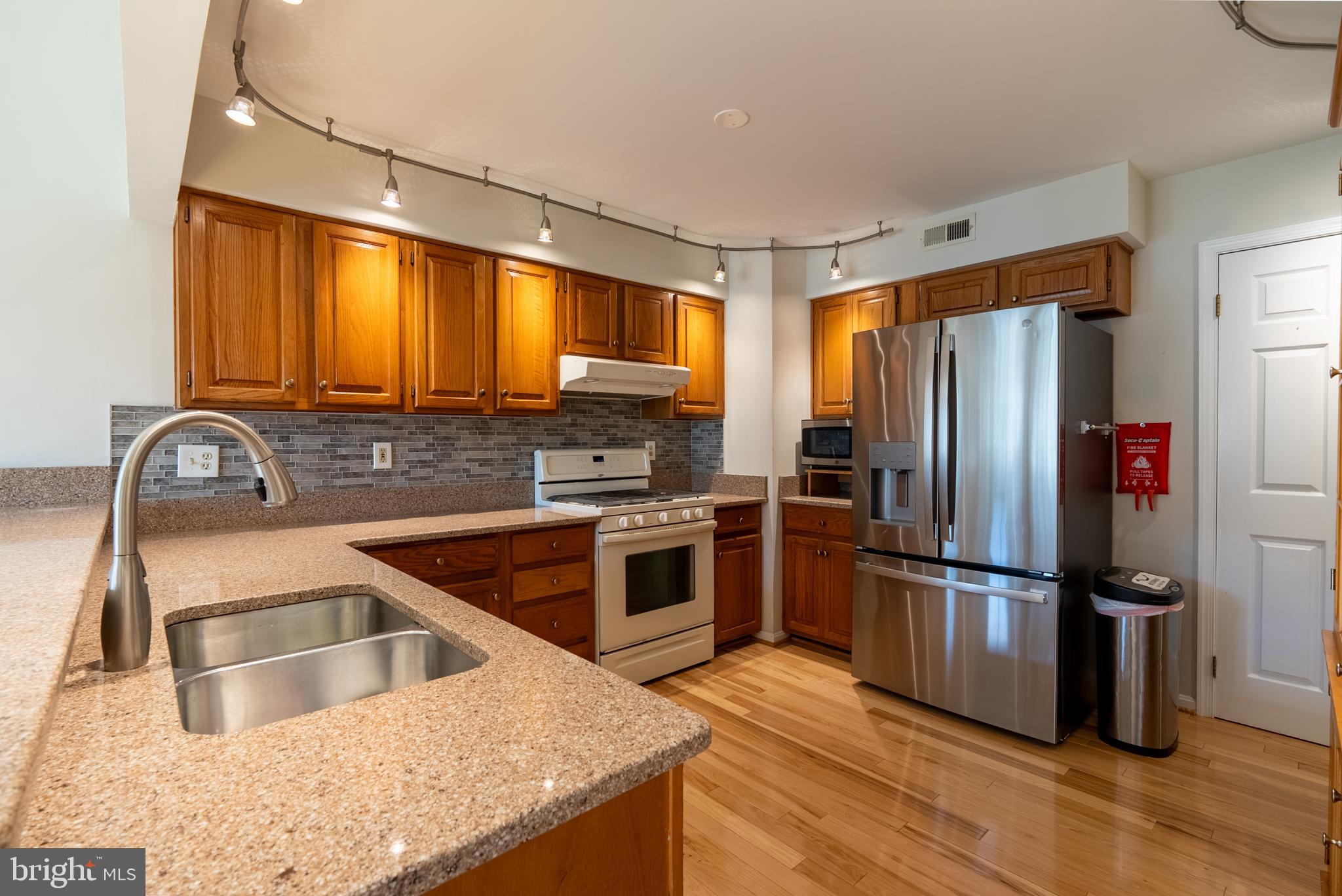 8007 Craddock Road Greenbelt, MD 20770 - Photo 11 of 59 Modern kitchen with warm wood accents.