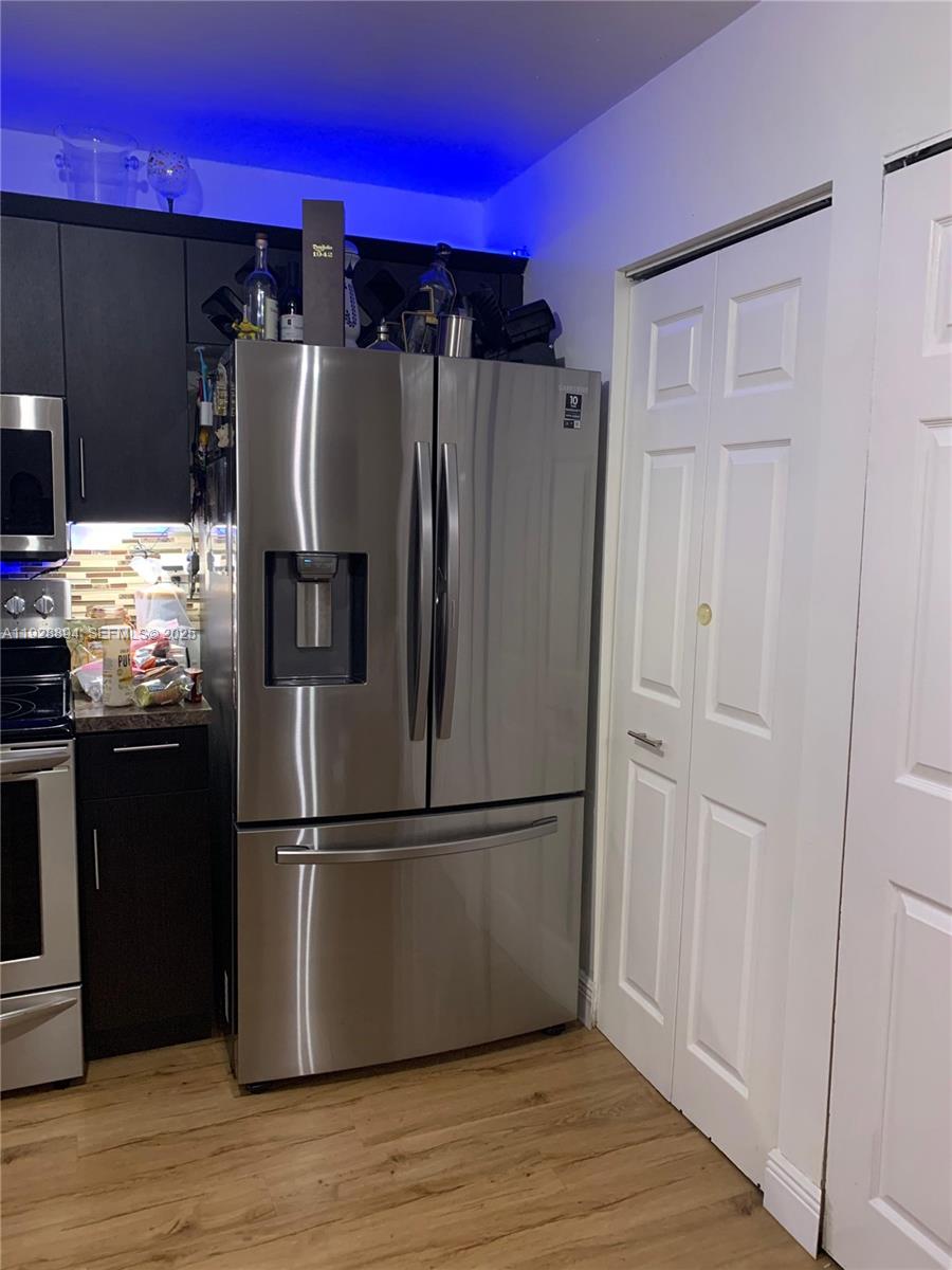 15228 Southwest 111th Street Miami, FL 33196 - Photo 11 of 27 a metallic refrigerator freezer sitting in a kitchen