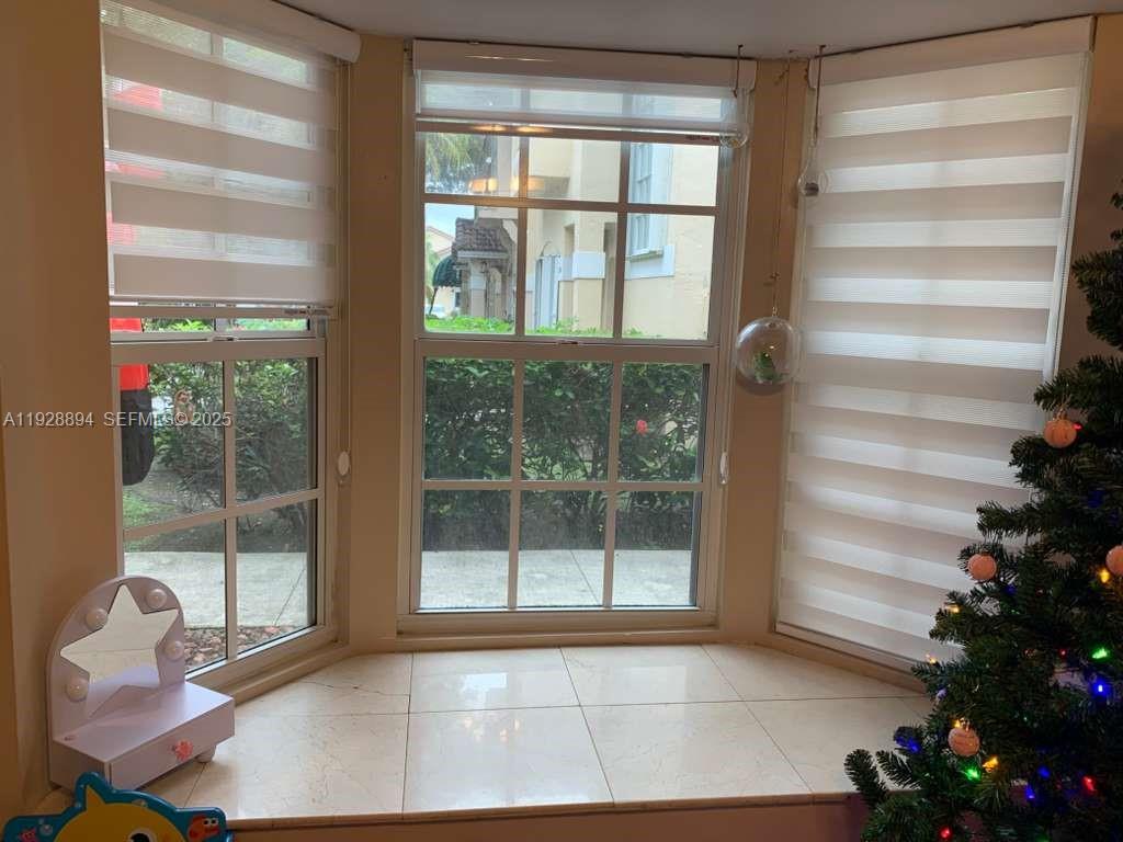 15228 Southwest 111th Street Miami, FL 33196 - Photo 6 of 27 a view of an empty room with a window and wooden floor