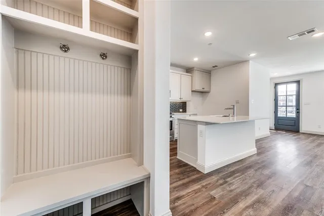 a kitchen with white cabinets and wooden floor
