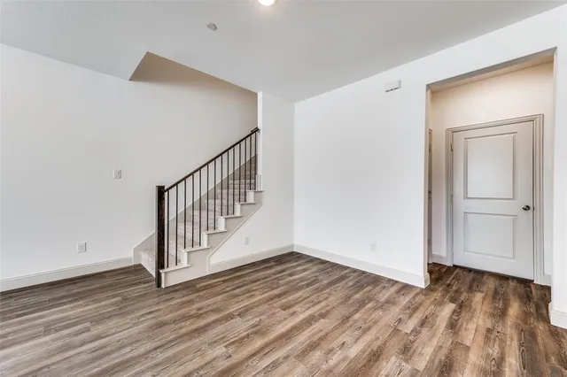 a view of a hallway with wooden floor and entryway