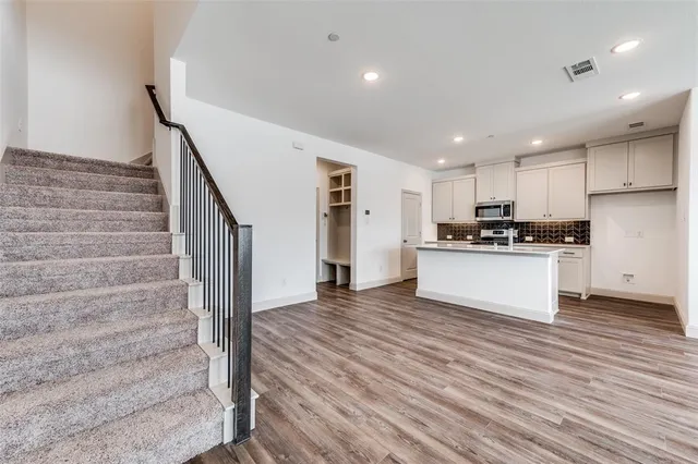 a view of kitchen with granite countertop cabinets and refrigerator