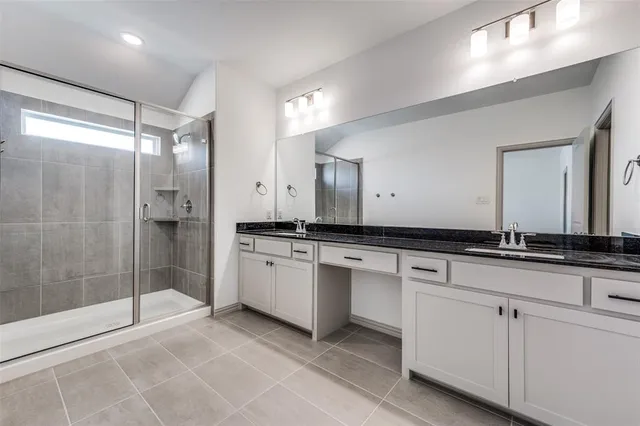 a spacious bathroom with a granite countertop sink mirror and shower